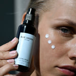 Fyrirsæta ber Hydrating Cream á kinn úr pumpuíláti